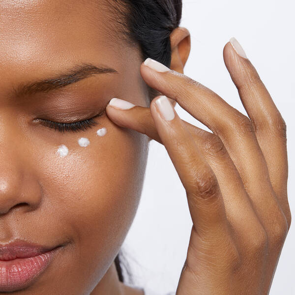 Frau, die sich IT Cosmetics unter die Augen cremt 