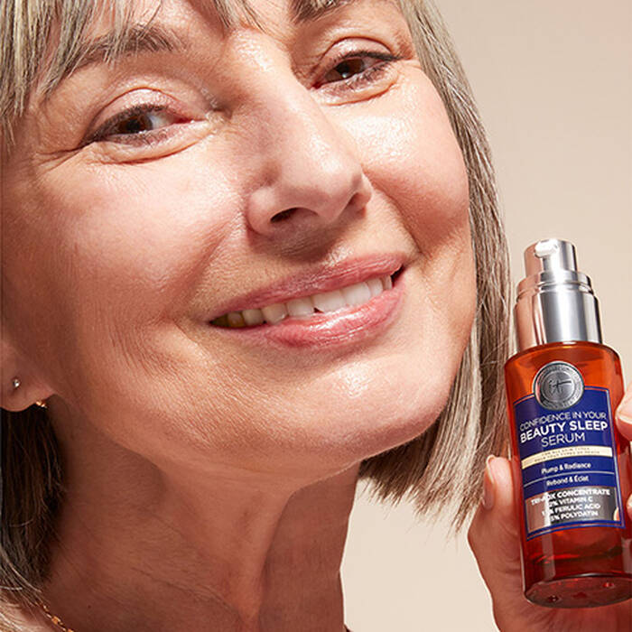 Frau halt das Confidence in your Beauty Sleep Serum neben ihr Gesicht